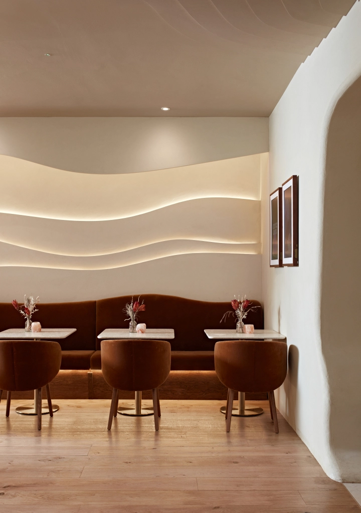 Banquette seating at Curve Club with sculpted ceiling lights and private dining tables