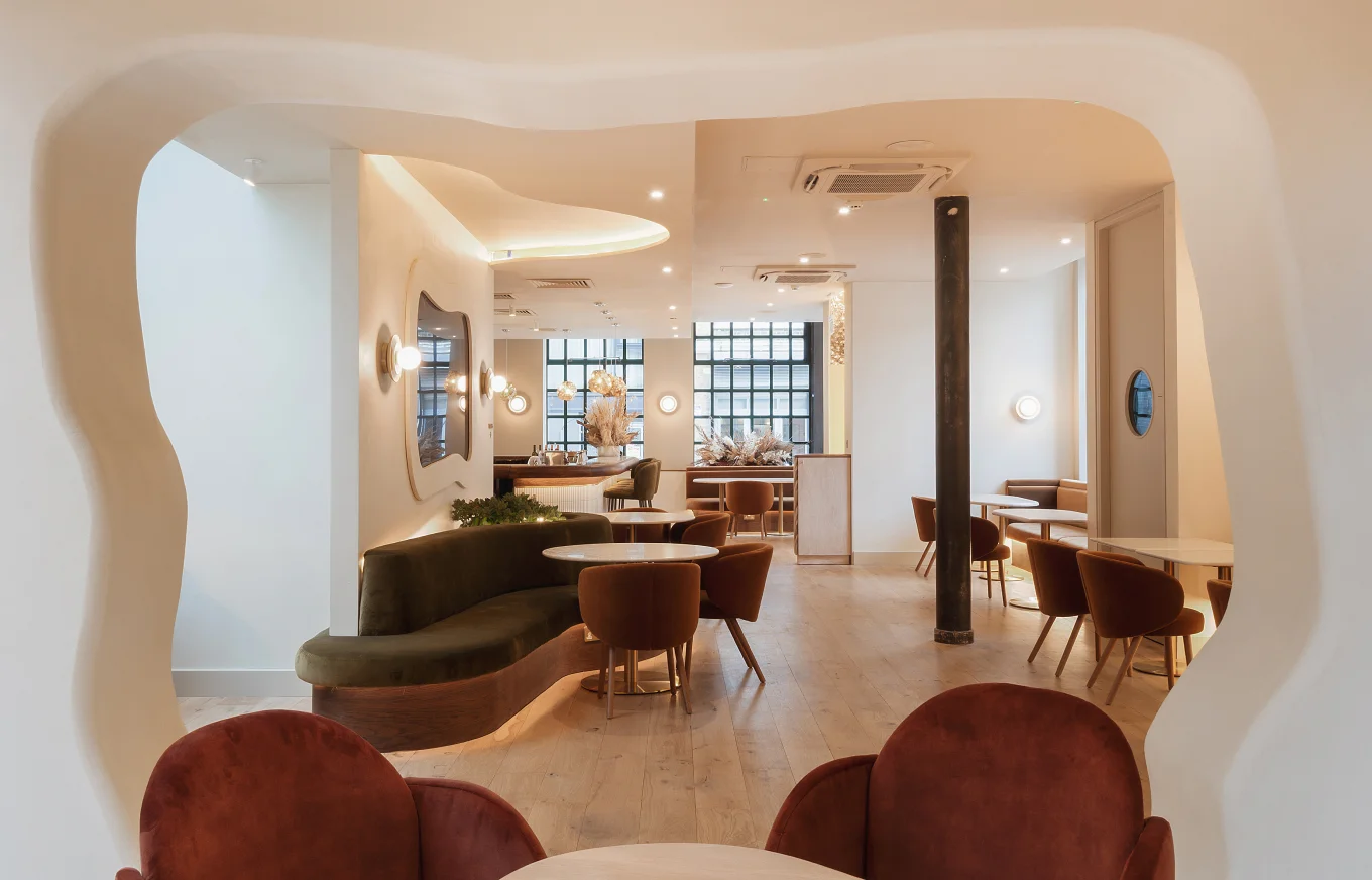 Open Curve Club lounge with curved archway, soft seating and warm lighting